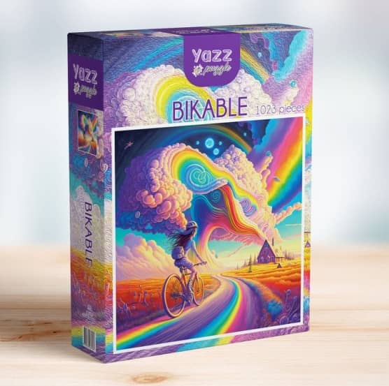 -Pyöräilijä palapeli (Bikable) on 1000 palan palapeli. Kuvassa pyöräilijä ajaa sateenkaaren väristä tietä kohti taloa. Valmistaja Yazz Puzzles.
